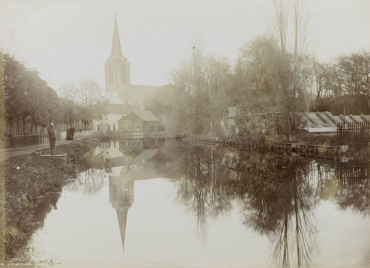 #63 View of a wide ditch with a road along it, and a church on the background, Netherlands, 1900