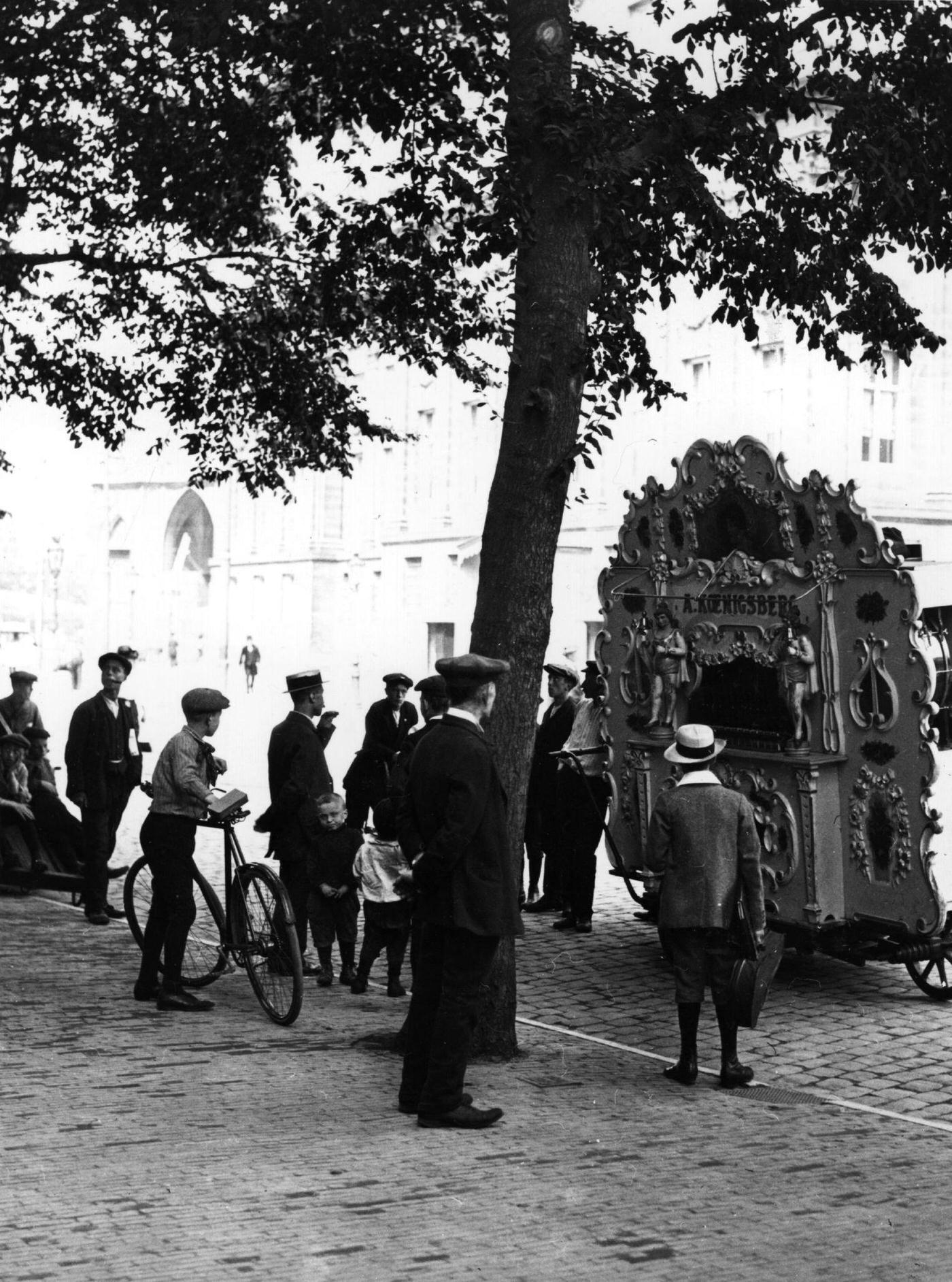 #87 Passers-by stop to listen to a barrel organ, in a town in Holland, 1900