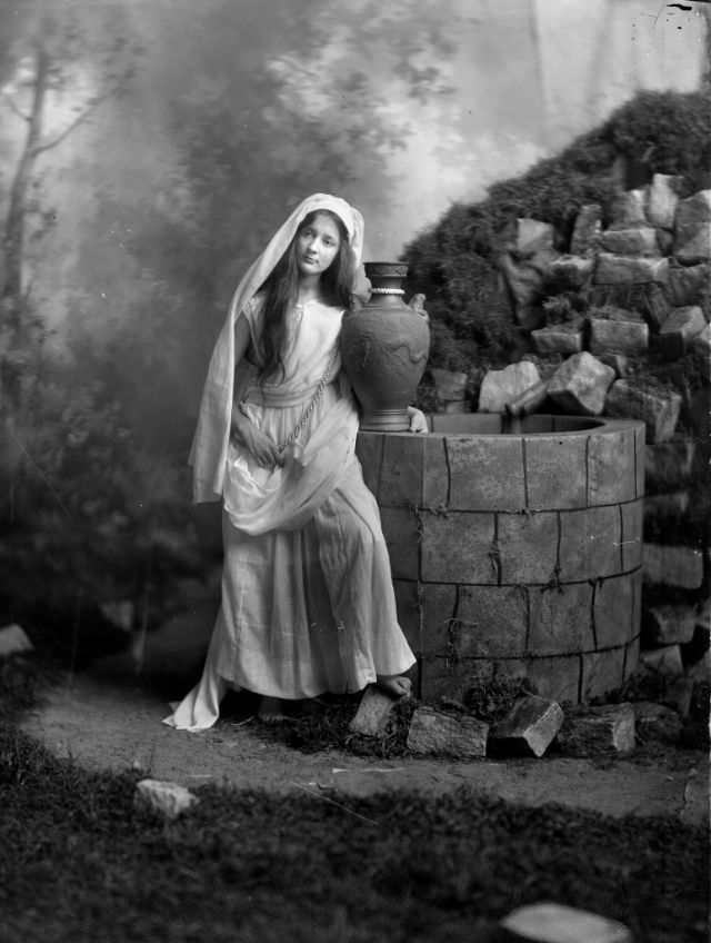 #16 Portrait of a young woman with urn by a well, 1910