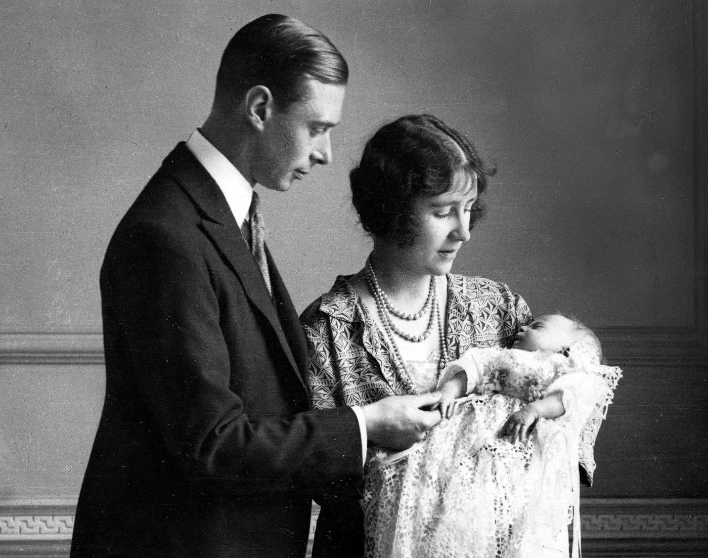 #2 The Duke and Duchess of York with their daughter (later, Queen Elizabeth II) as she sleeps in a precious christening robe, which has been used in the Royal Family for generations, 1926.