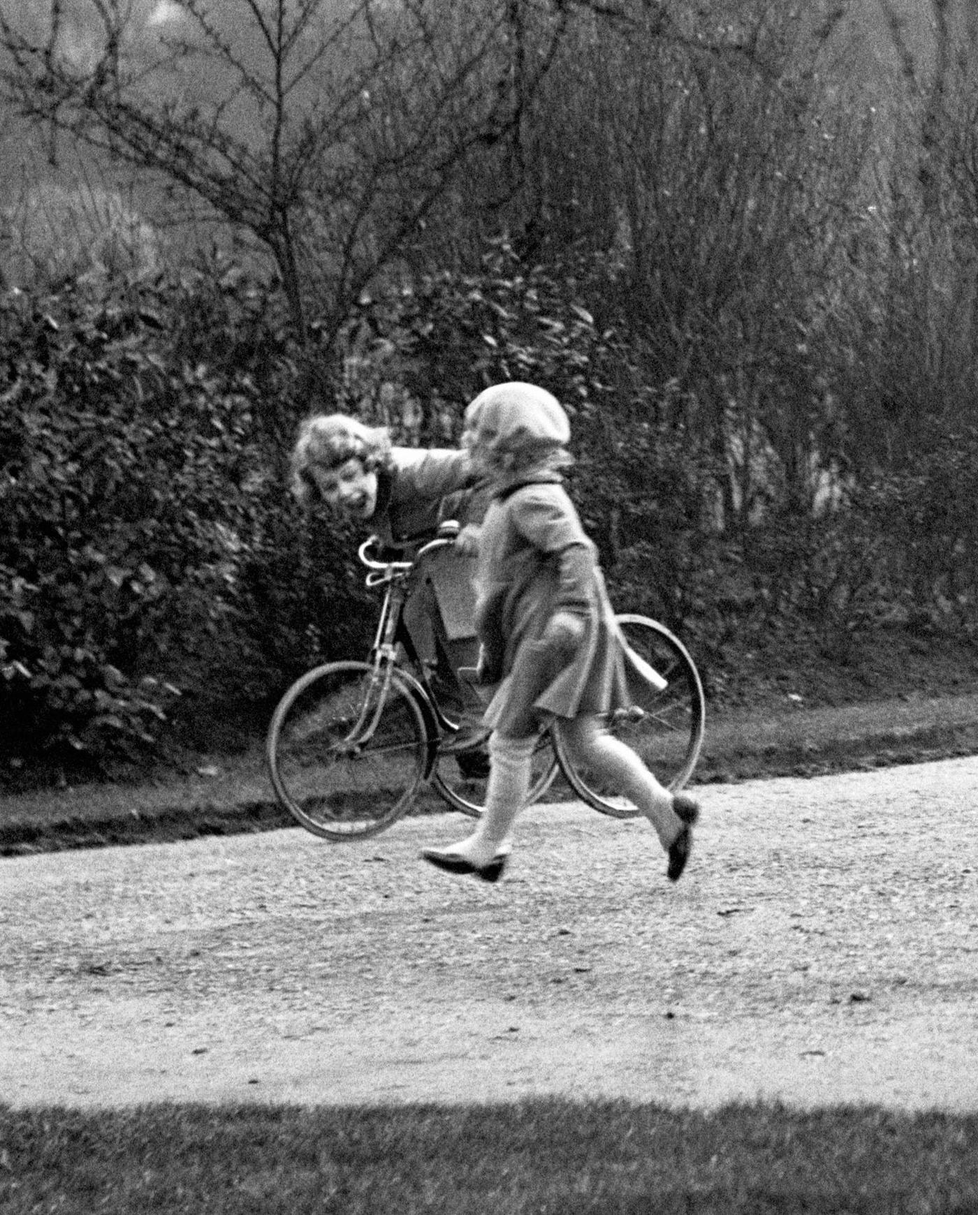 #48 Princess Elizabeth (later Queen Elizabeth II) is pictured on a tricycle in the park in this royalty photo.