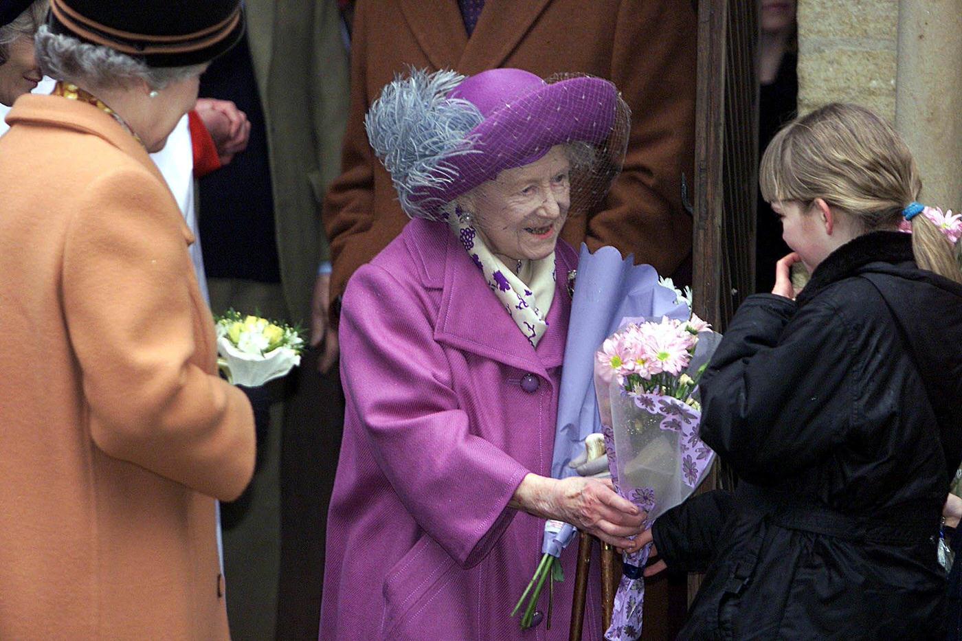 #131 The Queen Mother accepts flowers from a young girl as she attends a church service commemorating the death 100 years ago of Queen Victoria, 2001.