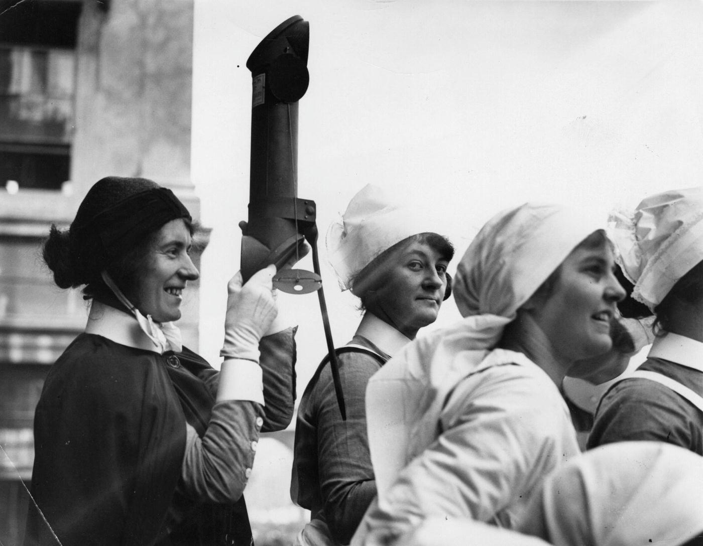#44 A nurse at St George’s Hospital watching the procession at the wedding of George VI to Lady Elizabeth Bowes-Lyon, through a periscope.