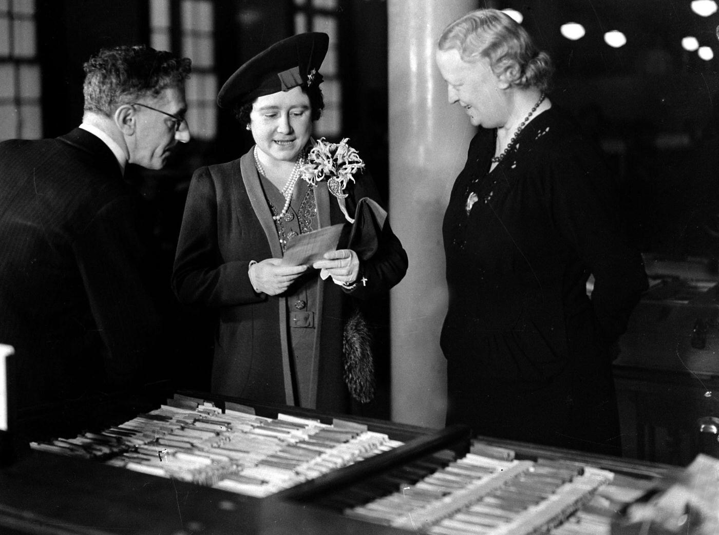 #90 Queen Elizabeth visiting a General Post Office building to learn about the Post Office Savings scheme, 1940.