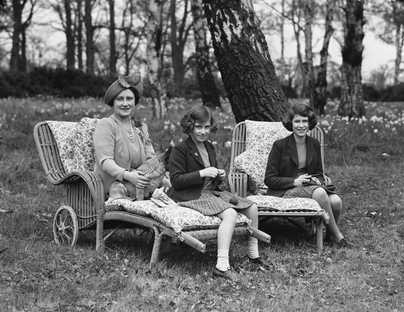 #95 Princesses Elizabeth and Margaret with Queen Elizabeth and a Pembroke Welsh Corgi dog at Royal Lodge, Windsor Great Park, 1940.