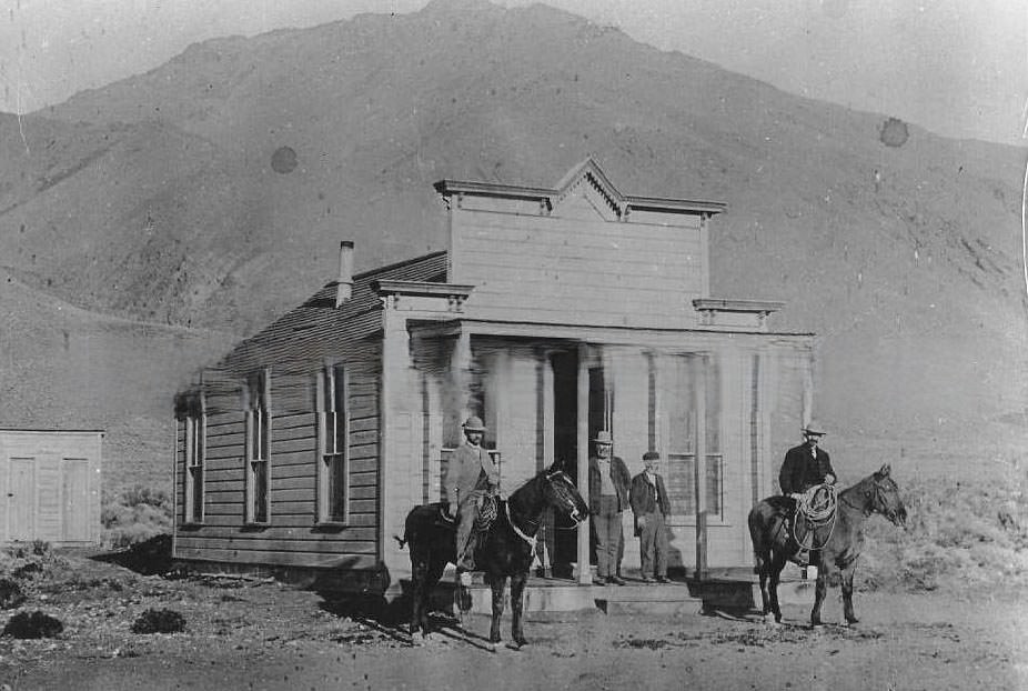 #123 Two men mounted on horses and two men standing on the porch of a house, 1890