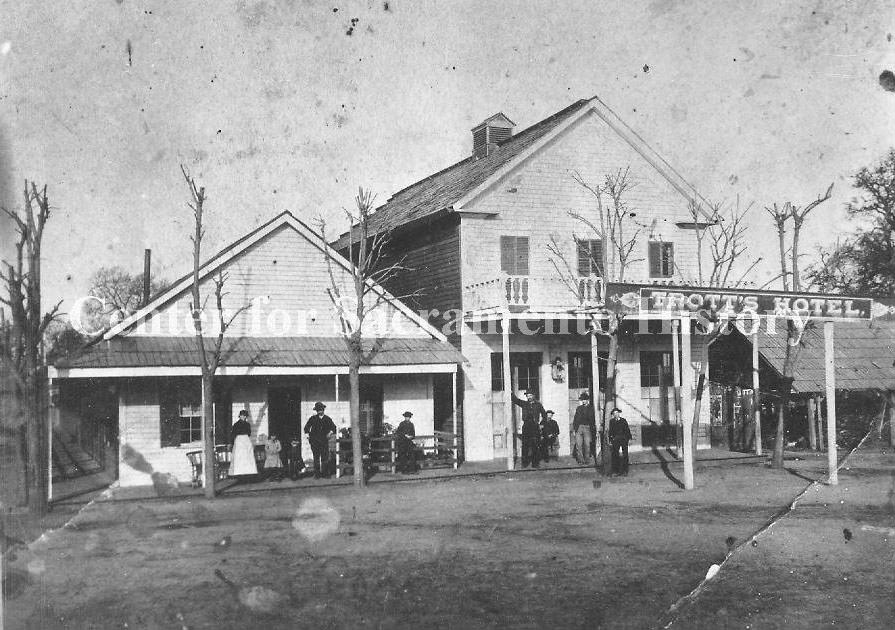 #163 View of several people standing on front porch of Trott’s Hotel, 1890