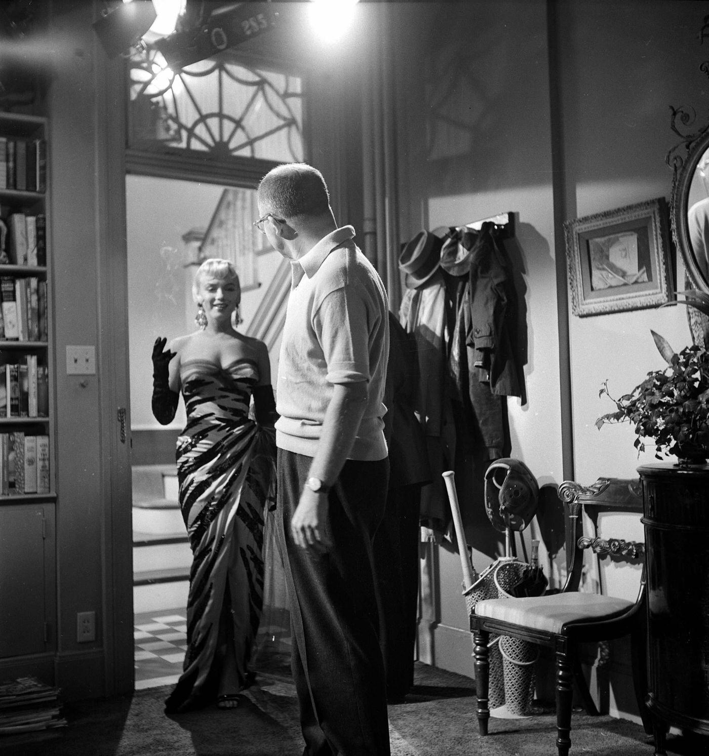 Monroe stands in a doorway wearing a tiger-striped dress on set with director Billy Wilder in 1954 during the filming of “The Seven Year Itch”