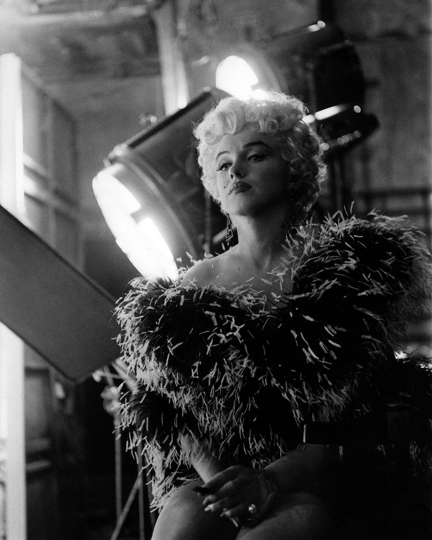 Marilyn Monroe wearing a feather boa in front of film set lights in 1954 during the filming of “The Seven Year Itch” in Los Angeles