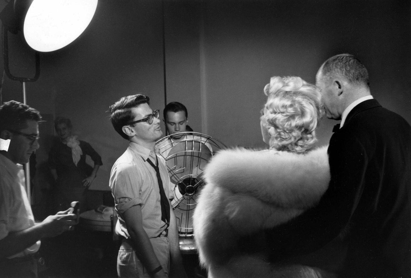 Marilyn Monroe stands wearing a white fur stole wrap with director Billy Wilder for a publicity shoot with Richard Avedon in his studio during the making of “The Seven Year Itch”