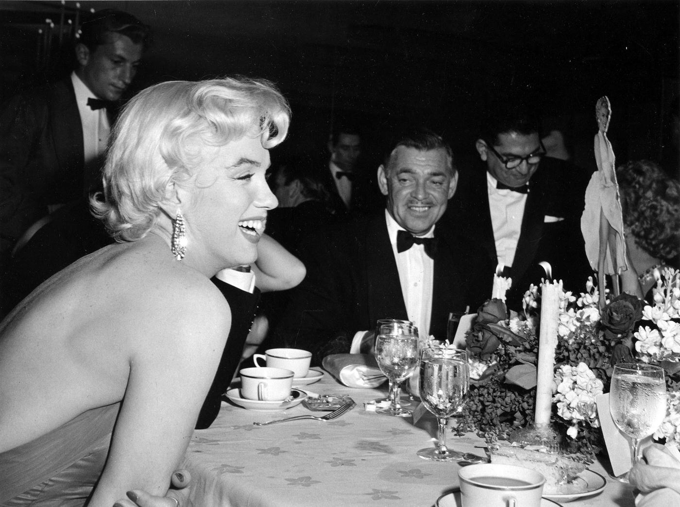 Marilyn Monroe with Clark Gable and newspaper columnist Sidney Skolsky at the wrap party for the filming of “The Seven Year Itch” at Romanoff’s Restaurant in 1954