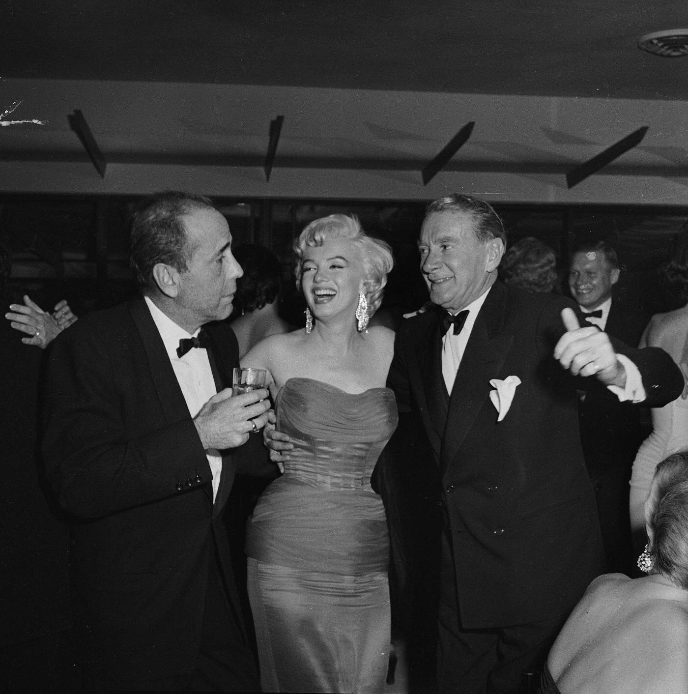 Marilyn Monroe with actors Humphrey Bogart and Clifton Webb at the wrap party for the filming of “The Seven Year Itch” at Romanoff’s Restaurant in 1954