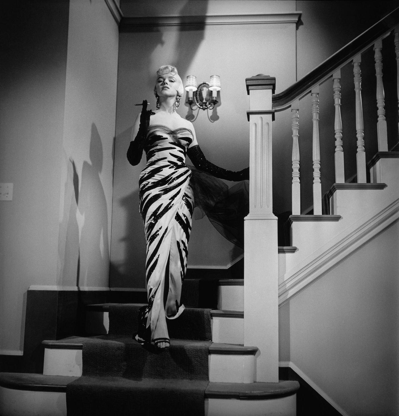 Marilyn Monroe descends a staircase wearing a tiger-striped strapless dress in 1954 during the filming of “The Seven Year Itch”