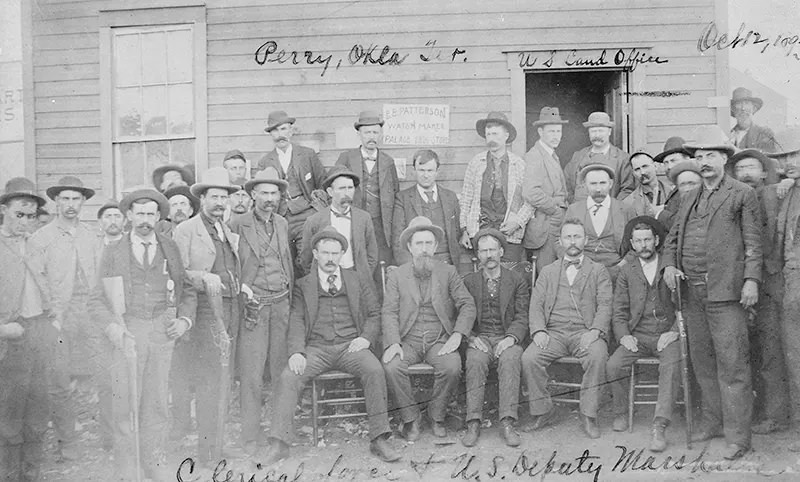#118 U.S. Deputy Marshals are seen posing with the clerical force in Perry, Oklahoma in 1893.