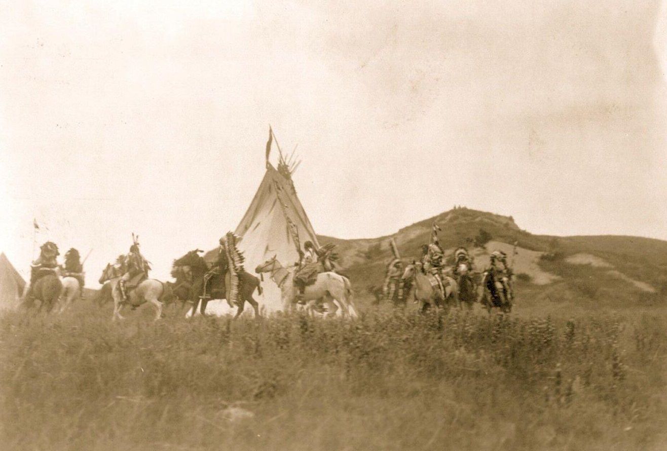 #6 Several Dakota men on horseback riding in a circle around a tipi, 1907