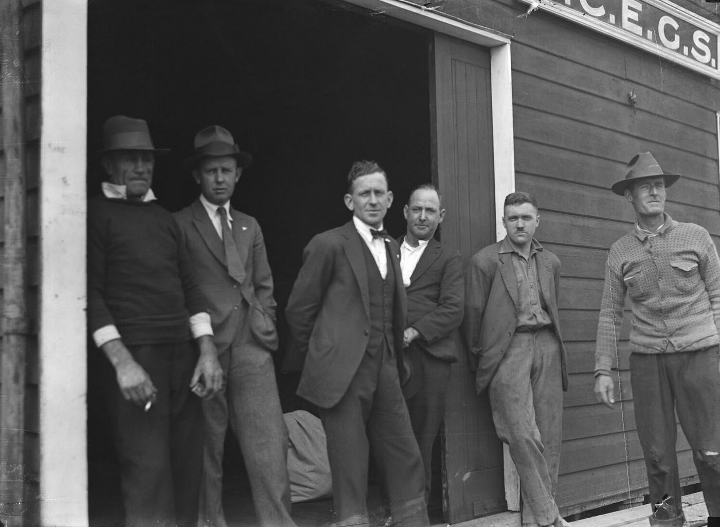 #44 Portrait of six men standing outside SCEGS Boatshed, Berry’s Bay
