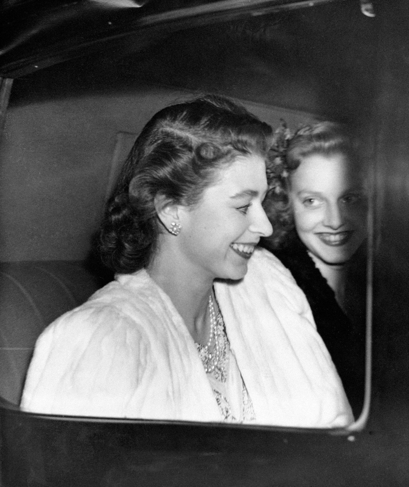 #101 Princess Elizabeth driving from Buckingham Palace, the day before the announcement by the King of the engagement of Princess Elizabeth and Lieutenant Philip Mountbatten, London, England, 1947.