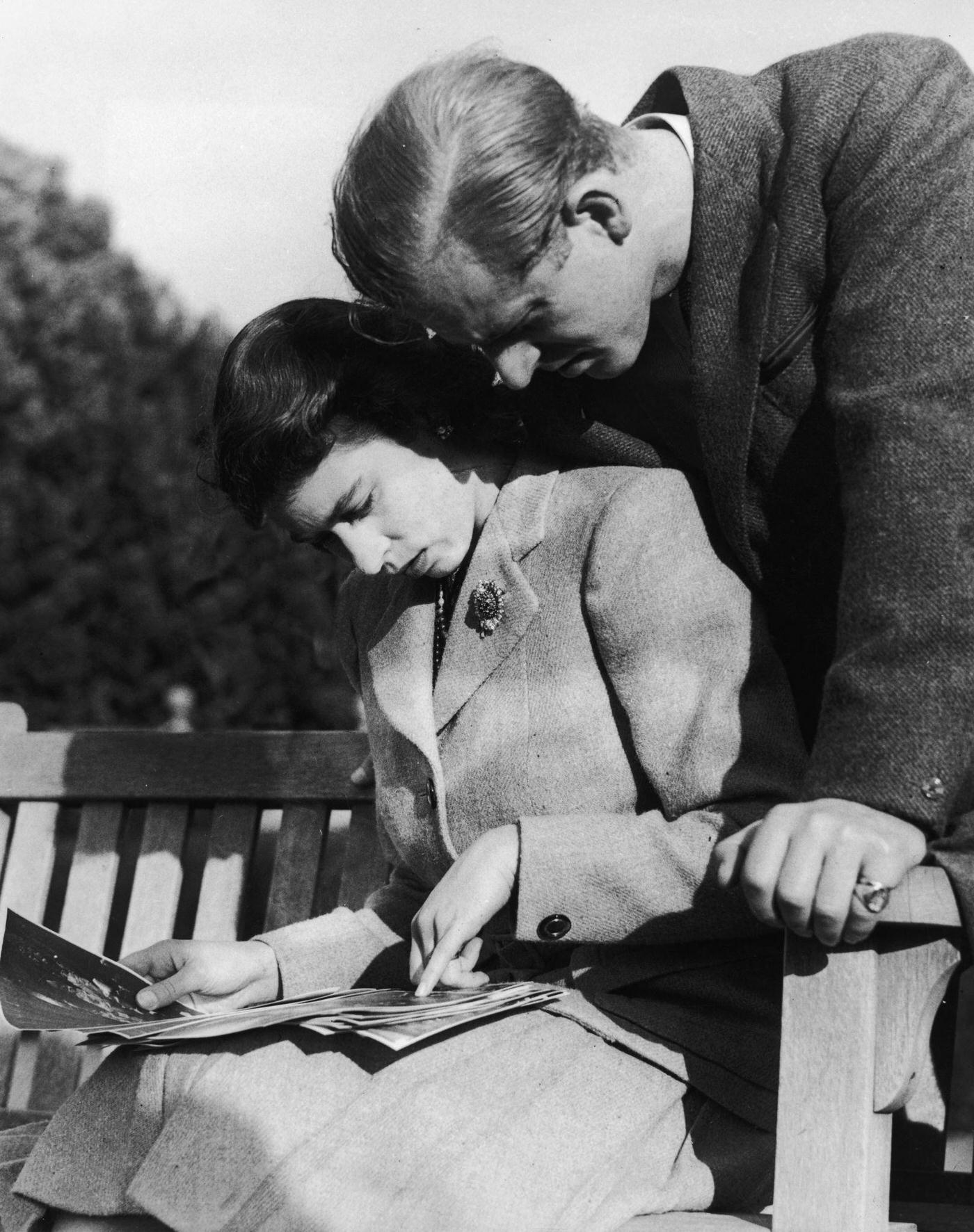 #103 Princess Elizabeth and Philip Mountbatten studying their wedding photographs while on honeymoon in Romsey, Hampshire, November 1947.