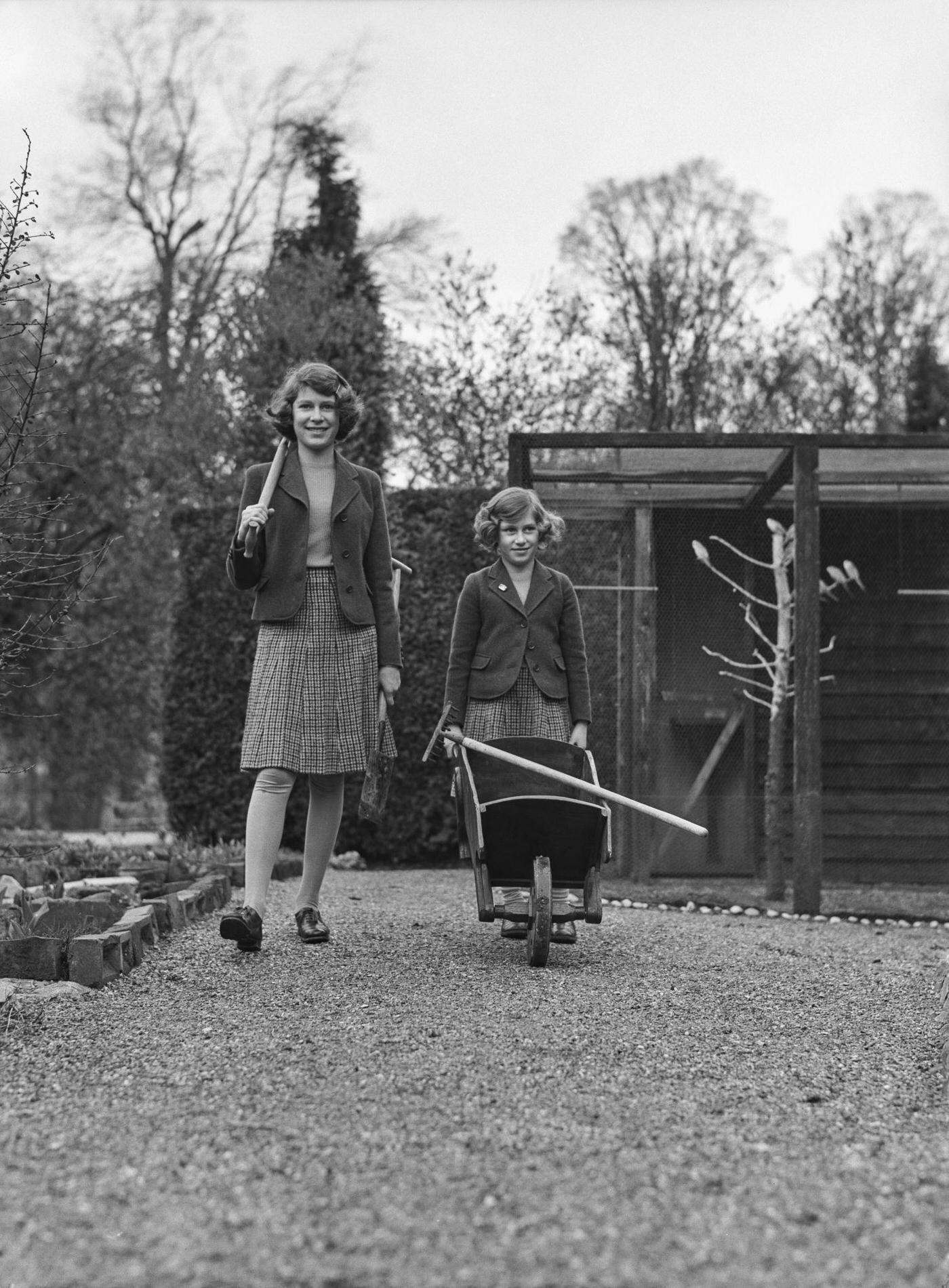 #32 The Royal Princesses Elizabeth and Margaret in their garden at the Royal Lodge in Windsor Great Park, UK, April 1940.