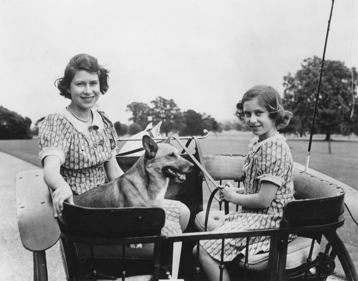 #48 Princess Elizabeth (now Queen Elizabeth II, left) and her younger sister Princess Margaret Rose (1930-2002) in a carriage in the grounds of the Royal Lodge in Windsor Great Park, 4th July 1940.