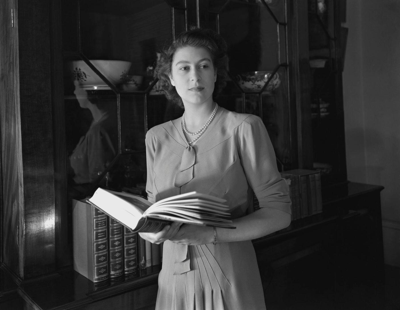 #82 Princess Elizabeth (Queen Elizabeth II) holding a book at Windsor Castle, Great Britain, 8 July 1946.
