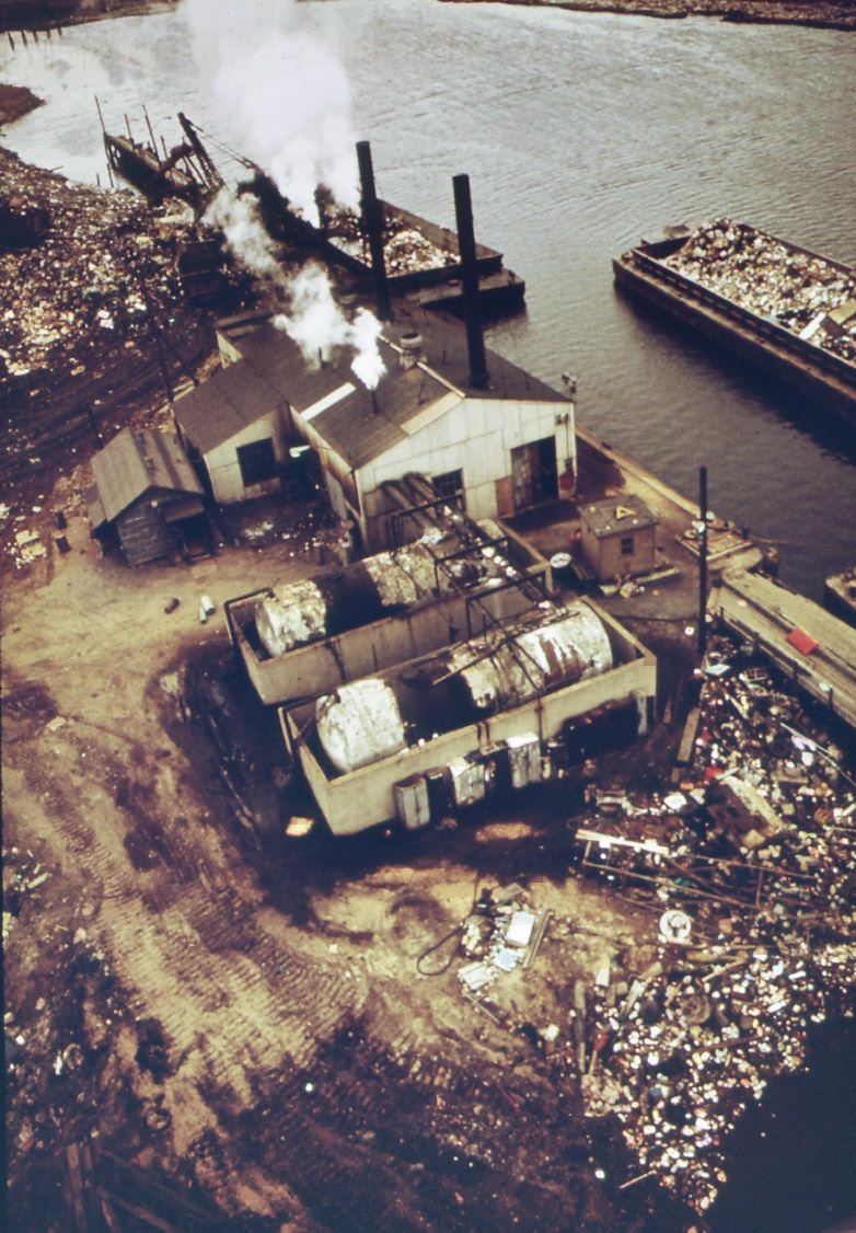 #66 Docks at fresh kills on staten island. Scows are laden with solid waste for use as landfill, 1970s