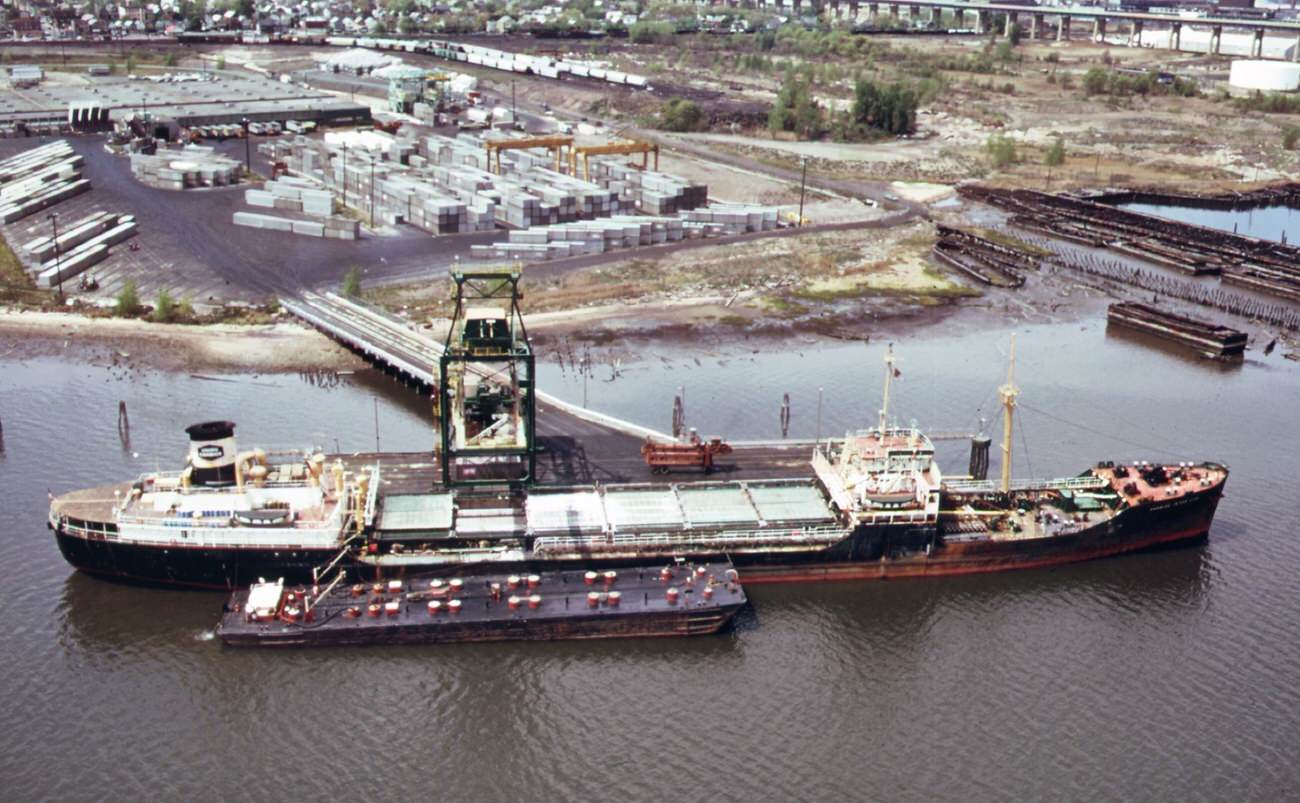 #83 Chemical and containerized shipping of the union carbide company in the arthur kill. In the background is the outerbridge crossing to staten island, 1970s