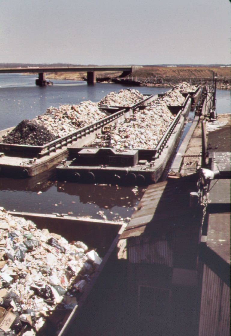 #98 Solid waste is towed down the east river in barges. At staten island, it is transferred to carts, and then dumped at the already overflowing landfill, 1970s