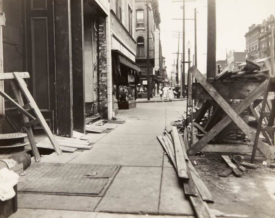 #10 Sidewalk repair on South Broadway near its intersection with Lafayette. The sign and storefront for the Heitmeyer Drug Co. can be seen in the background, 1930