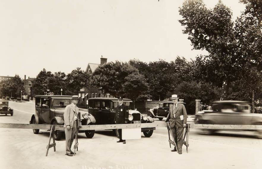 #37 Union and Lindell boulevards, 1931 – A police officer and two other men standing next to a wooden traffic barricade at the intersection of Lindell and Union boulevards.