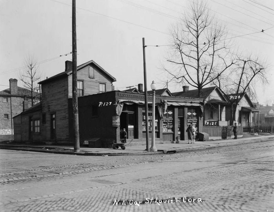 #94 Boy at Joseph Pollard’s corner confectionery, 4633 St. Louis Ave. Two women chat next door at Michael Nolan’s grocery store at 4631, 1930