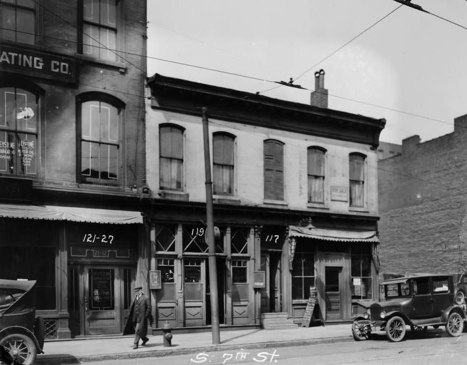 #153 View of several storefronts on the 100 block of South 7th Street between Walnut and Elm. Keystone Lubricating Company, St. Louis Wholesale Drug Company, and James Robinson’s restaurant are visible, 1930