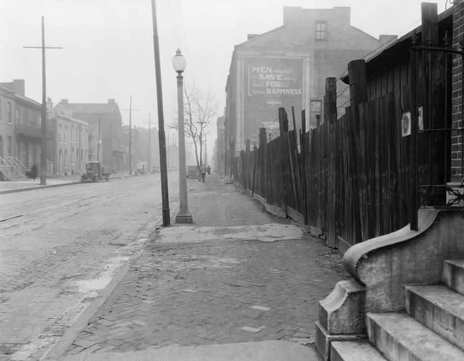 #7 View of North Tenth St. near O’Fallon St., including a junkyard, with a building painted with the message “Men who fail to save surely must forfeit future happiness”, 1930
