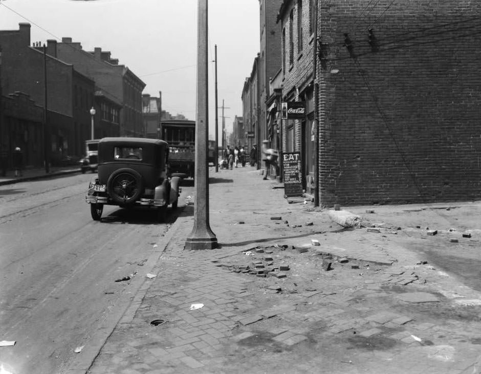 #25 View of sidewalk in front of an empty lot between 1505 and 1509 Biddle, with John Noffsinger’s restaurant at 1509 Biddle visible, 1931