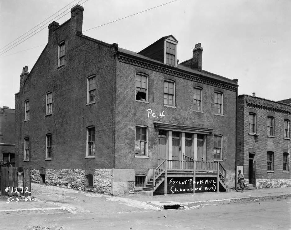 #5 View of multi-family brick dwelling on Forest Park Ave. with a woman on the sidewalk, 1932.