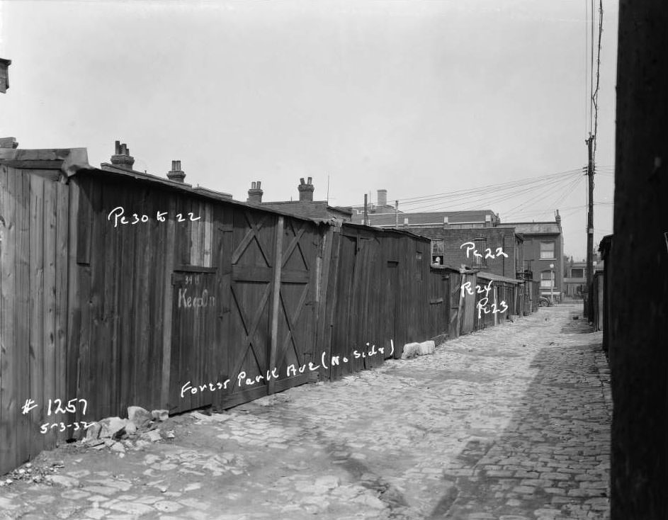 #57 View of sheds and garages on Forest Park Ave. alley, north side, with “Keep Out” written on one door, 1932.