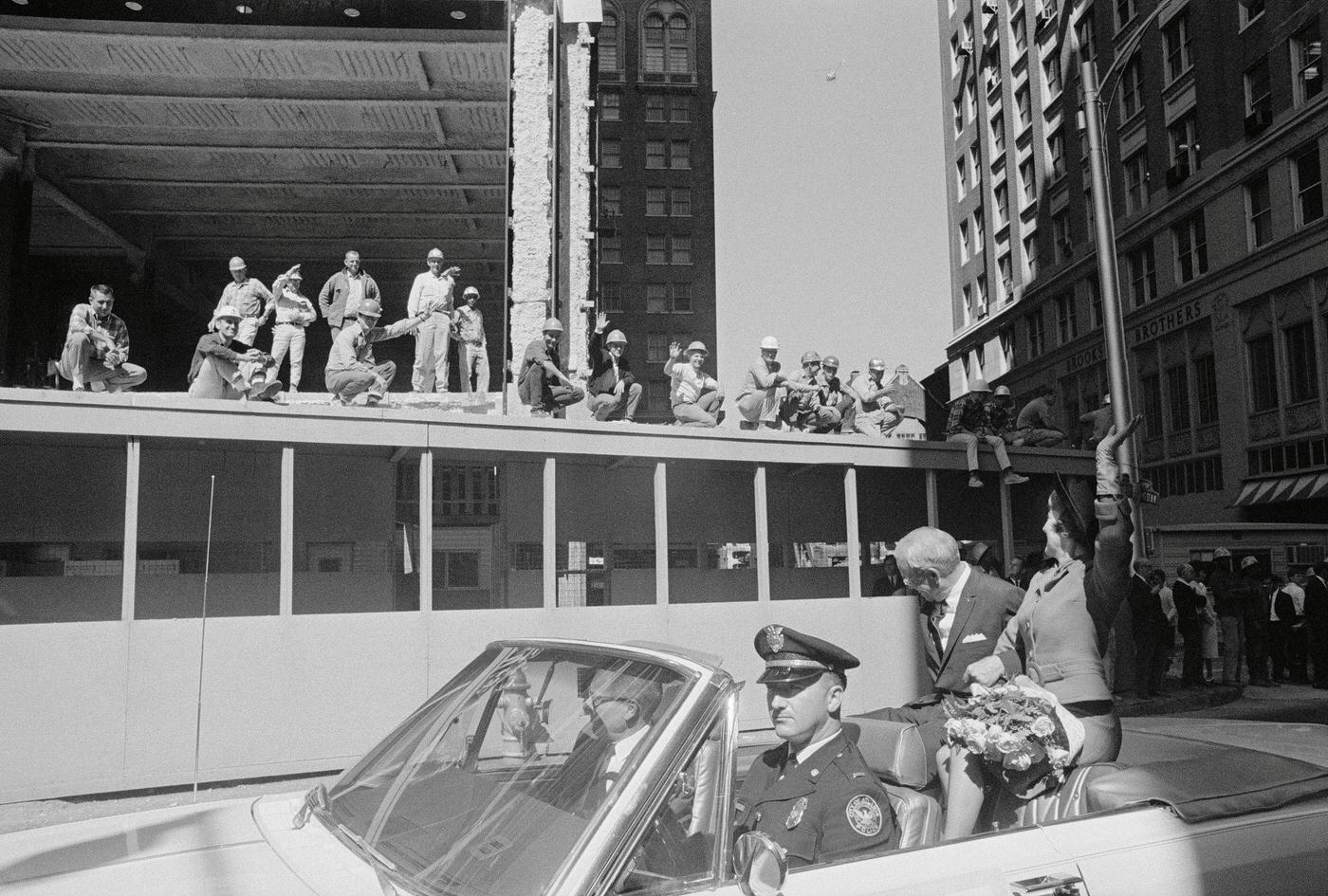 #7 A group of construction workers takes time off to wave to actress Olivia de Havilland (far right) passing in an open car with Atlanta Mayor Ivan Allen, 1960s