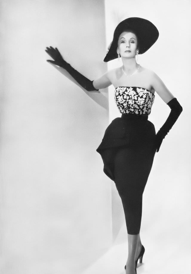 #15 Barbara Goalen in white-sequined embroidered bodice with jet black accents and black faille skirt worn with black velvet hat and gloves, all from Debenham & Freebody, 1950.