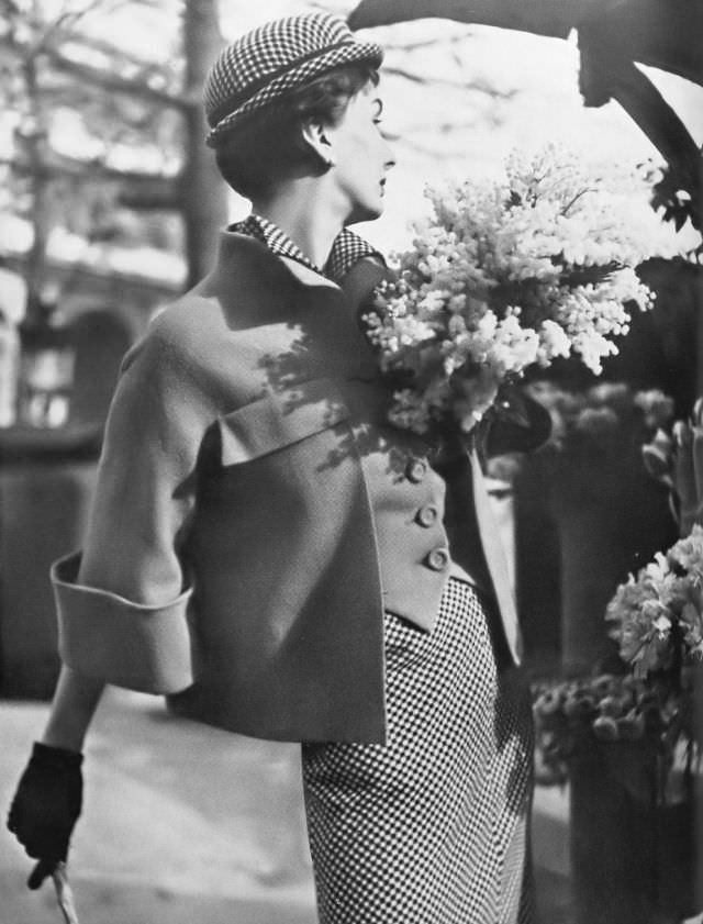 #3 Barbara Goalen in black and white check shirtdress under an orange jacket fitted like a waistcoat in front and swinging loose behind by Robert Piguet, 1950.