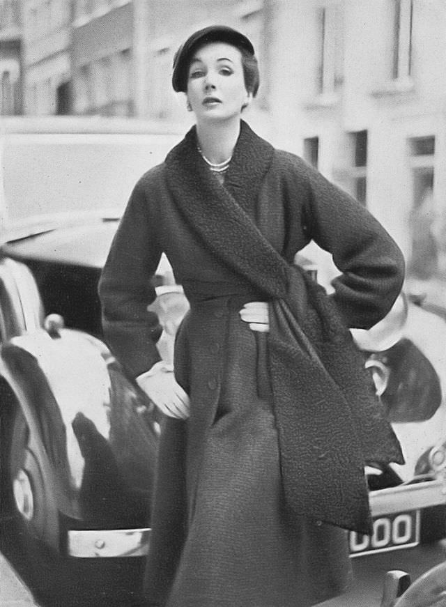 #30 Barbara Goalen in liquorice-colored ribbed bouclé coat with a collar and cross-over sash of black Persian lamb by Digby Morton, hat by Rudolf, 1952.