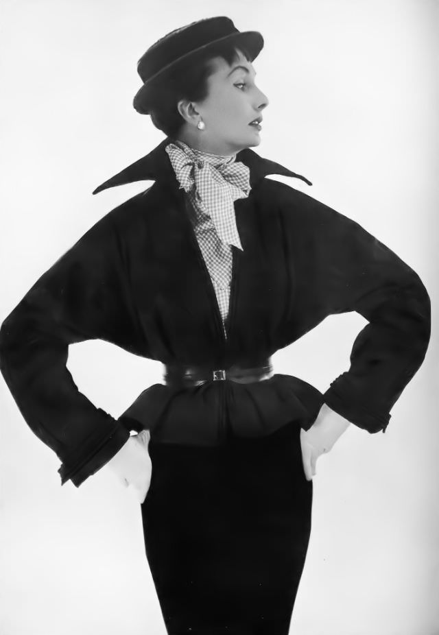 #4 Barbara Goalen in black poult jacket, bloused, belted and high-collared, over mauve-and-white checked shirt and wine-red boater, by Victor Stiebel, 1950.