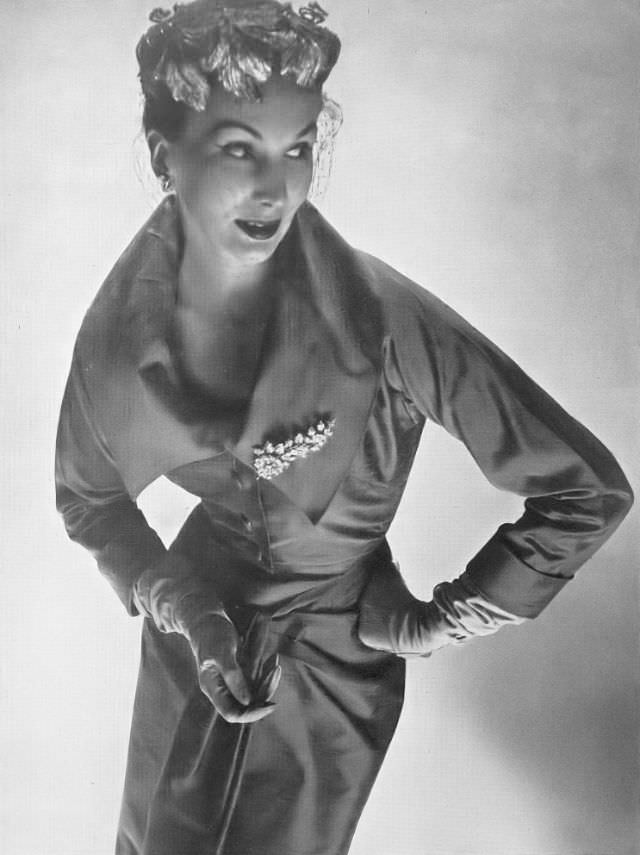 #42 Barbara Goalen in close-fitting jacket with the look of a bodice over a halter-neck dress by Dorville, 1953.