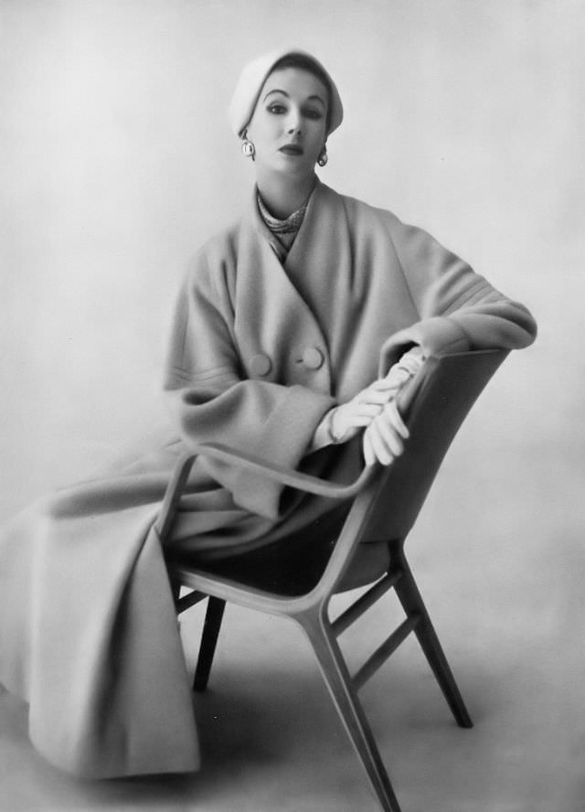 #45 Barbara Goalen in pale apricot fluid velours coat, sleeve sinset with triple stitching by Spectator Sports, felt hat by Lady Vassar, 1953.