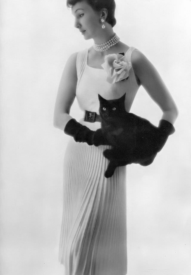 #9 Barbara Goalen in hand-knit dress in white spintex, beautifully pleated in rib-stitch with low back and two straps across by Angèle Delanghe, 1950.