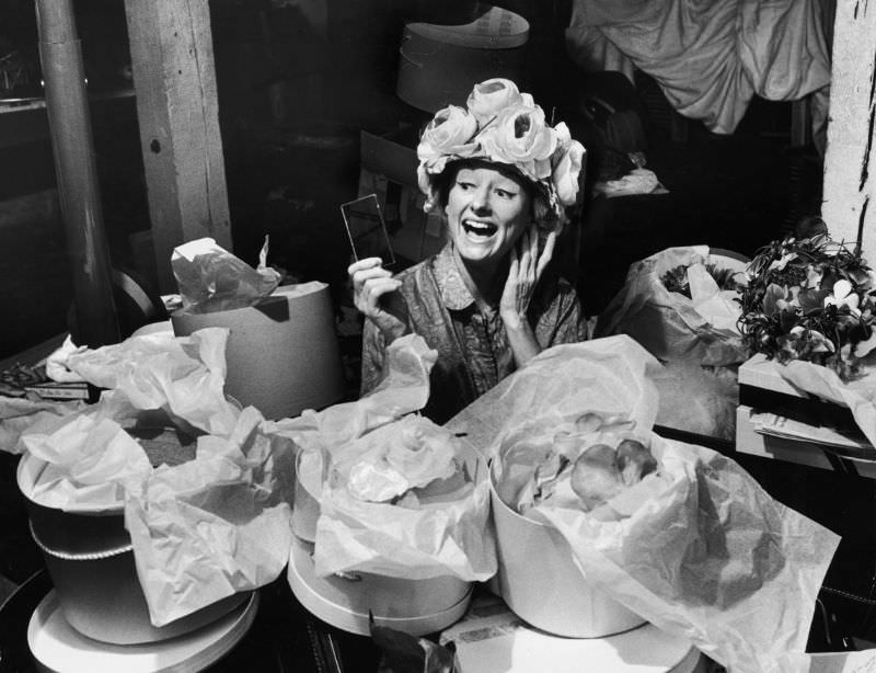 #25 Phyllis Diller sits amid a large collection of hat boxes in the basement of her St. Louis home, 1963.