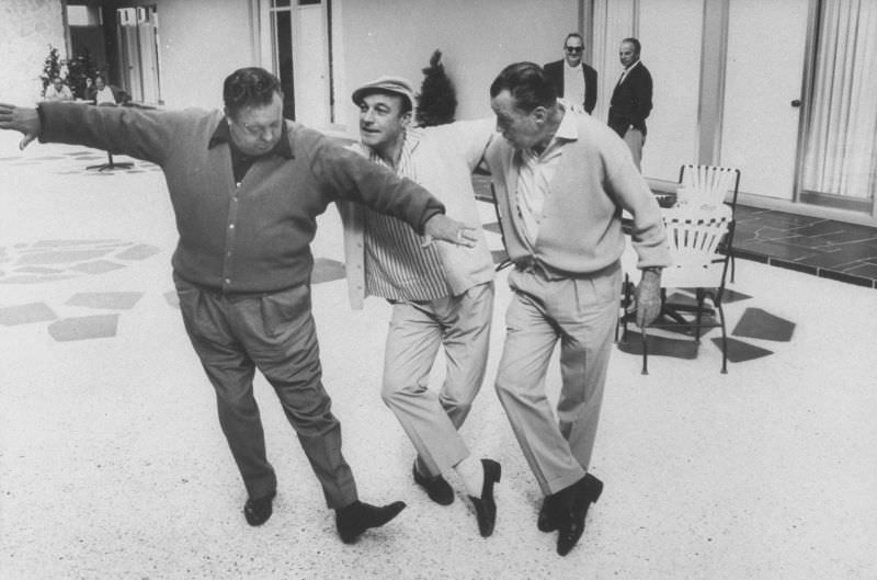 #28 Actors Jackie Gleason and Gene Kelly casually tap dancing Ed Sullivan during visit to Gleason’s studio, 1967.
