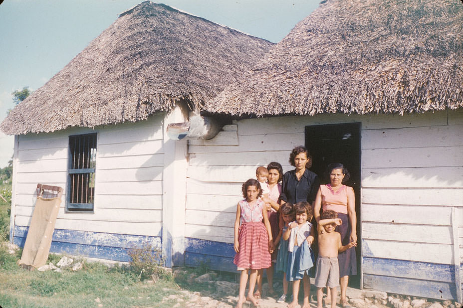 #4 Cuban family in front of blue and white house with thatched roof