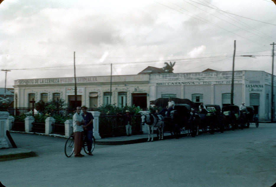#10 Horse drawn taxis parked by plaza, Casanova store, Sagua La Grande