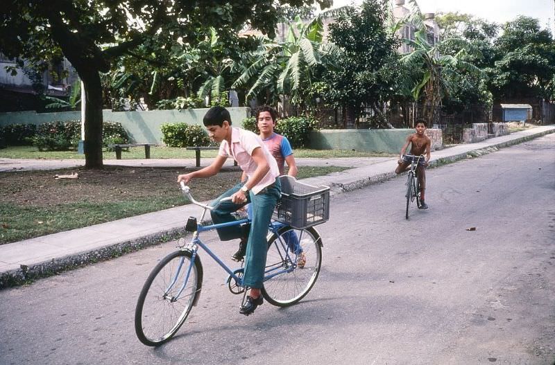 #50 Three boys, two on bicycles, on a street in the Miramar neighborhood, Havana.