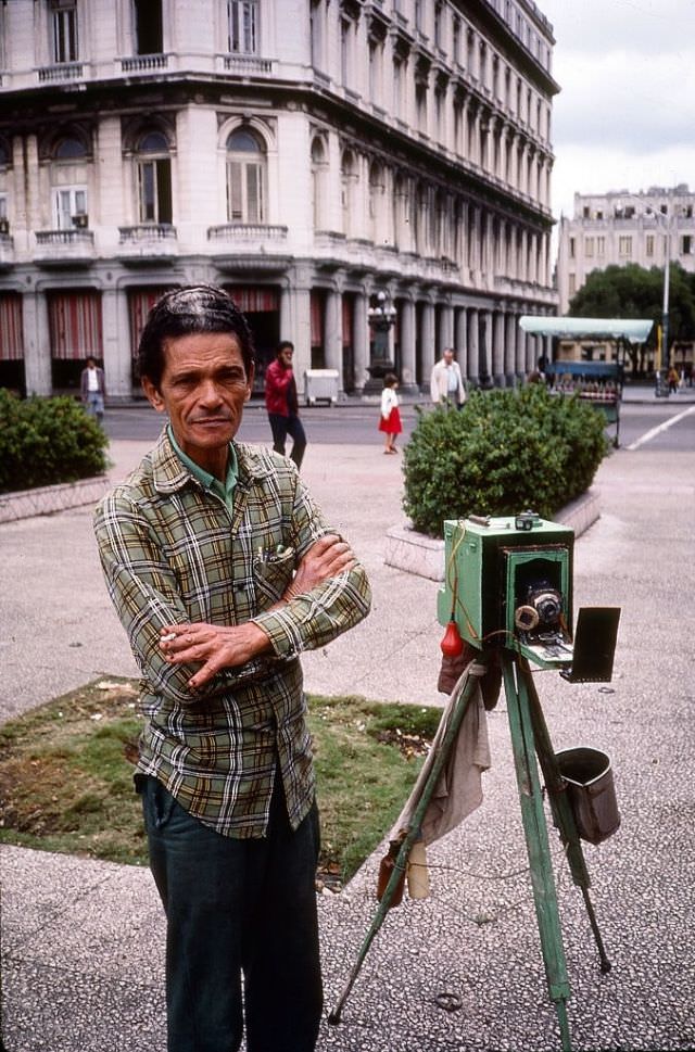 #53 Portrait of a street photographer, beside his tripod and camera, near the Plaza de la Revolucion, Havana.